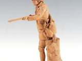 wooden statue of a man with a gun on a tree stump
