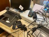 un bureau sur lequel se trouvent un ordinateur portable, une imprimante, un téléphone portable et d'autres appareils électroniques