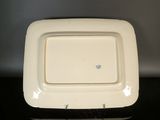 a white plate with a blue flower on it on a table
