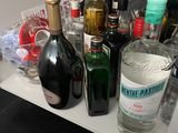 many bottles of alcohol sitting on a shelf in the kitchen