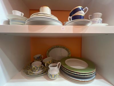 de nombreuses assiettes et tasses sur les étagères de la cuisine