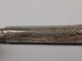 an image of a silver pen with a dragon design on it