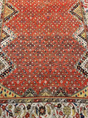 un tapis oriental à fond rouge et à bordure dorée
