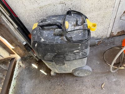 un petit ventilateur posé par terre près d'un mur