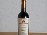 une bouteille de vin rouge posée sur une table en bois