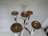 four silver candlesticks sitting on a white table