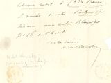 un vieux document sur lequel figure une lettre manuscrite, posé sur une feuille de papier