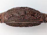 an old wooden box with carvings on it on a white surface