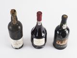three bottles of wine sitting next to each other on a white surface