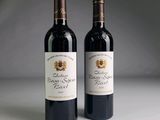 two bottles of red wine sitting next to each other on a table