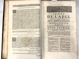 un livre ouvert sur une table, sur lequel est collée une étiquette