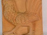 des sculptures représentant un oiseau et un coq sont exposées sur une surface blanche