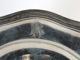 a silver plate with a design on it on a table