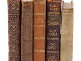 plusieurs vieux livres sont empilés sur une surface blanche