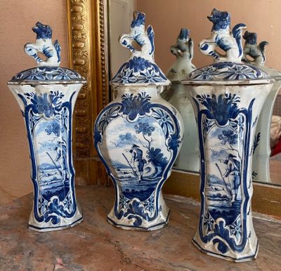three blue and white vases sitting on a table next to a mirror