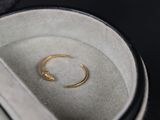 une bague en or posée dans une boîte avec une paire de ciseaux