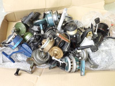 a cardboard box filled with assorted fishing reels and reels