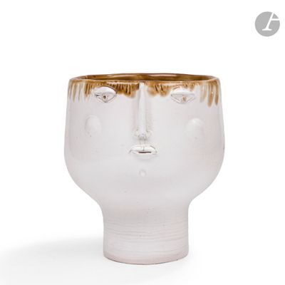 un vase blanc orné d'un visage brun