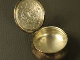 a small silver container sitting on top of a table