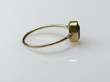 an image of a gold ring with a black stone on it