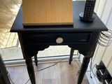 a small desk with a laptop and a cell phone on it