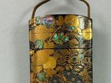 a gold and black purse hanging on the wall