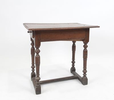 une vieille table en bois aux pieds tournés, sur fond blanc
