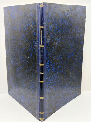 un vieux livre à la couverture bleue posé sur une table blanche