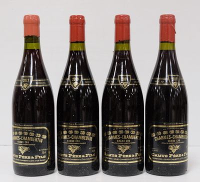 four bottles of wine are lined up on a white surface