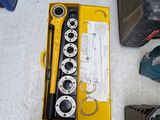 une boîte à outils posée par terre à côté d'une paire de chaussures