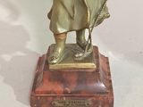 a bronze statue of a man holding a dog on a leash