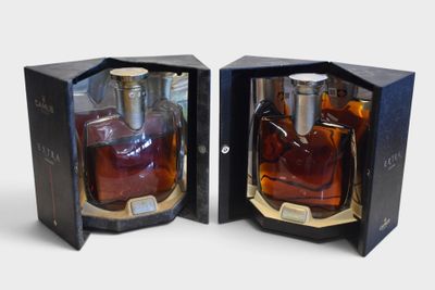 two bottles of whiskey in a black box on a white surface