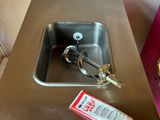 a sink with a toothbrush and toothpaste in it