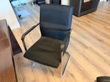 a black office chair sitting in the middle of a wooden floor