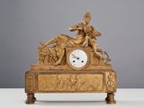 une horloge en or surmontée d'une statue