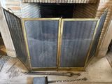 a fireplace with a screen and a shovel in front of it