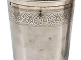 an antique silver cup with a floral design on the rim