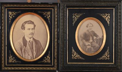 deux photographies encadrées représentant un homme et une femme, dans des cadres noirs et dorés