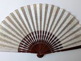 a white and brown fan on a white wall