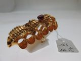 an image of a gold bracelet with a garnett on top of it
