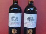 deux bouteilles de vin rouge posées sur une table rouge