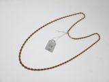 une photo d'un collier muni d'une étiquette, posé sur une surface blanche