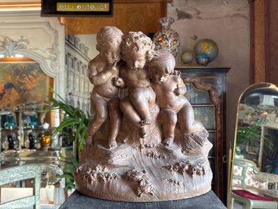 a statue of a group of children sitting on a rock