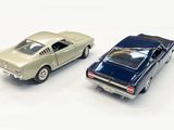 two toy cars sitting next to each other on a white surface