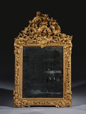 un miroir ancien avec un cadre doré sur fond noir