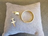 une bague, une croix et une bague posées sur un coussin
