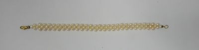 a close up of a yellow beaded bracelet on a white surface