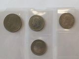 several different coins are in a plastic case on a white surface