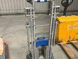 un chariot élévateur avec un levier bleu dans un entrepôt