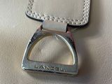 a close up of a white purse with a ring on it